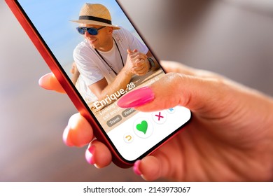 Woman using online dating app on her mobile phone - Shutterstock ID 2143973067