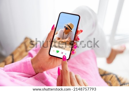 Woman using online dating app on phone and viewing someone's profile