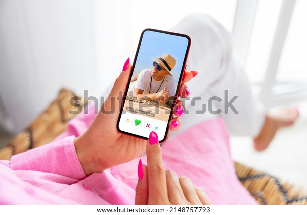 Woman using online dating app on phone and
viewing someone's profile