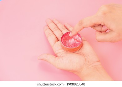 woman using petroleum jelly on pink background  - Shutterstock ID 1908823348