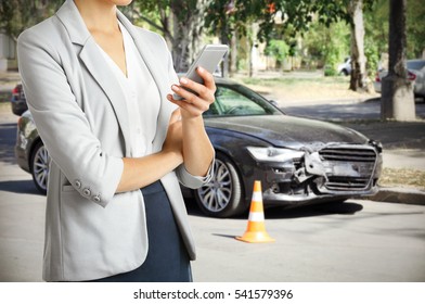 Woman using phone after car accident, closeup. Traffic safety concept.