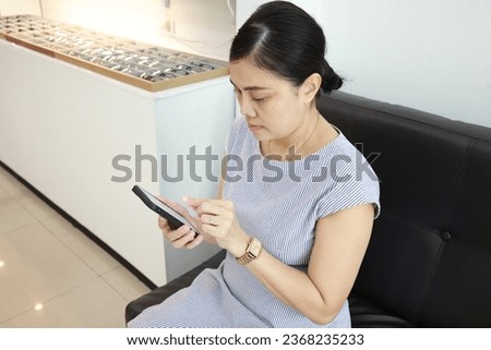 Woman using phone at home, women holding mobile phone