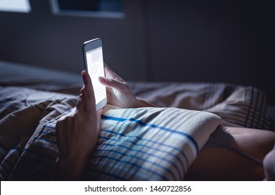 Woman Using Phone Late At Night In Bed. Person Looking At Text Messages With Cell In Dark Home. Hipster Online Dating Or Texting With Smartphone. Sexting Or Cheating Concept. Smart Device Screen Light