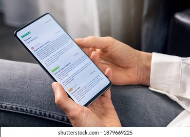 Woman Using Phone To Read Customer Reviews About Service And Product Quality Before Online Shopping