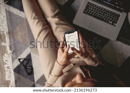 Woman using phone sitting on floor. Payment.  Online shopping concept.Concept of blogging. Top view.
