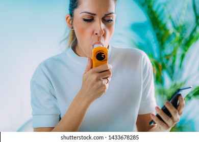 Woman Using Portable Spirometer And A Smart Phone App