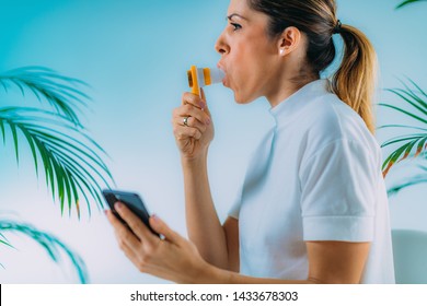 Woman Using Portable Spirometer And A Smart Phone App