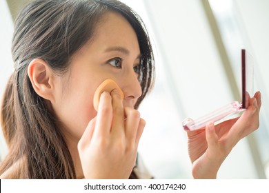 Woman using powder to touch up on her face