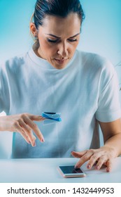 Woman Using Pulse Oximeter And Smart Phone, Measuring Oxygen Saturation 