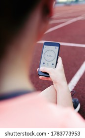 Woman Using A Running App In Smart Phone And Checking Performance.