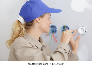 Woman Using Screw Driver During Socket Installation
