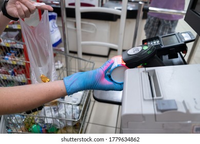 woman using self service checkout in a store.