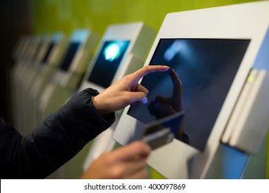 Woman using the self services terminal to pay on the fare