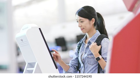 Woman using selfie check in machine in the airport