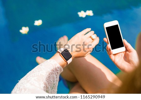 Woman using smart digital tech by the pool