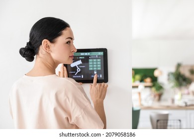 Woman Using Smart Home Security System Control Panel