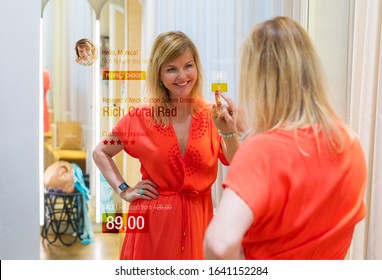 Woman Using Smart Mirror Technology In Store's Fitting Room