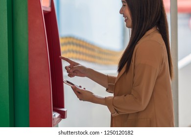 Woman Using The Smart Mobile Phone For Withdrawing In Front Of The ATM, Business Automatic Teller Machine Concept