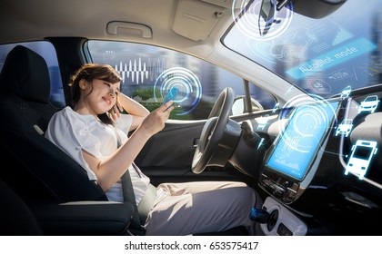 Woman Using Smart Phone In Autonomous Car. Self Driving Vehicle. Driverless Car. Autopilot. Automotive Technology.