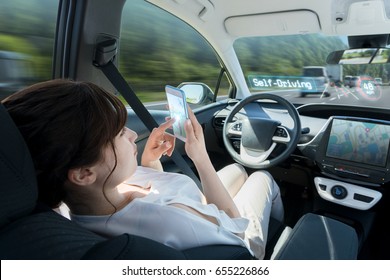 Woman Using Smart Phone In Autonomous Car. Self Driving Vehicle. Autopilot. Automotive Technology.