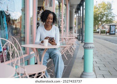 Woman using smart phone during coffee break in sidewalk cafe - Powered by Shutterstock