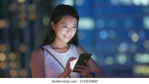 Woman Using Smart Phone At Night