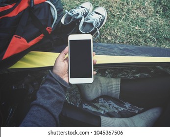 Woman Using Smart Phone On Hand At Tent Camping