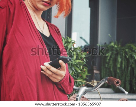 Woman using smart phone on hand and bicycle