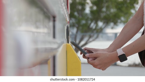 Woman Using Smart Phone To Pay Of Vending Machine 