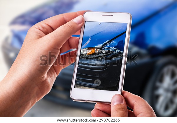 a woman using a smart phone to take\
a photo of the damage to her car caused by a car\
crash