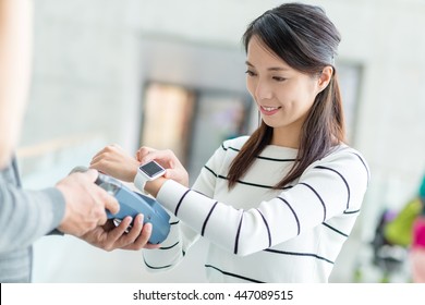 Woman Using Smart Watch To Pay On Pos Terminal
