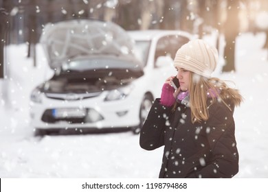 Woman using smartphone to call road assistance. Winter and vehicle concept. - Powered by Shutterstock