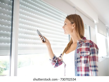 Woman using smartphone to control electric shutter