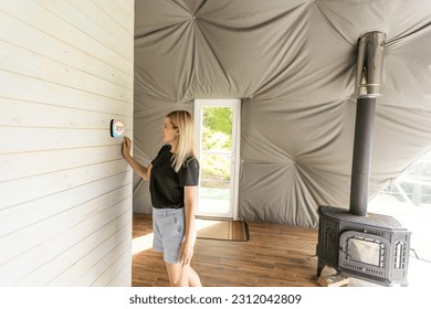 Woman using smartphone to control home connectivity interface - Shutterstock ID 2312042809