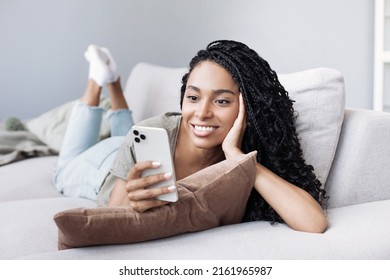 Woman Using Smartphone At Home. African American Girl Looking At Mobile Phone. Enjoy Life, Fun, Leisure, Communication, Connection, Relaxation, Modern Lifestyle, Technology, People Concept