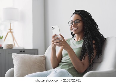 Woman using smartphone at home. Mixed race girl looking at mobile phone. Communication, leisure, connection, mobile apps, technology, learning, web chat, lifestyle concept