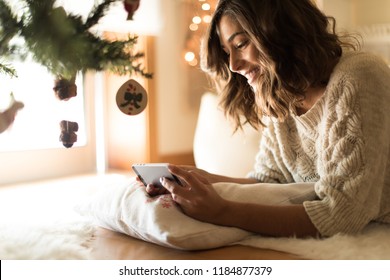 Woman using a smartphone at home - Winter and Christmas Season