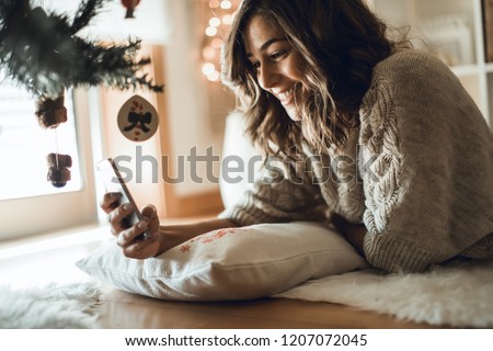 Woman using a smartphone at home - Winter and Christmas Season