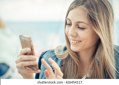 Woman using smartphone and looks at cellphone