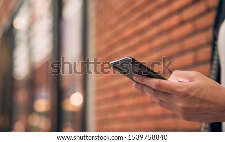 Woman using smartphone at the mall. type message online to friends.