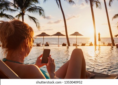 Woman Using Smartphone On Beach Luxury Hotel Near Swimming Pool, Travel App For Tourist On Mobile Phone