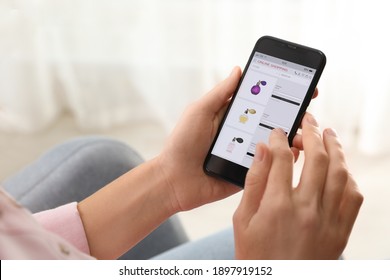 Woman using smartphone for online shopping indoors, closeup