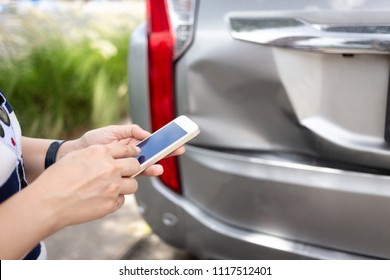 Woman using smartphone at roadside after traffic accident,traffic safety and insurance concept