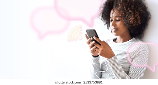 Woman using smartphone, smiling, sitting against a wall. Engaged with phone, relaxed. Casual setting, young woman, enjoying her smartphone. Digital device, technology, and communication.  - Powered by Shutterstock