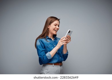 Woman using smartphone for video conversation. Portrait of smiling girl on gray back.
