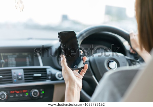 Woman using smartphone while driving, cause of\
car accident, Distracted\
Driving.