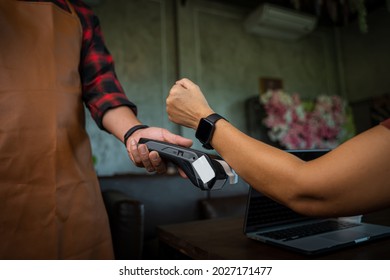 Woman Using Smartwatch To Pay By NFC Technology,Customer Pays A Bill Payment Via A Smartwatch.