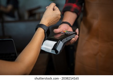 Woman Using Smartwatch To Pay By NFC Technology,Customer Pays A Bill Payment Via A Smartwatch,Buy And Sell Products.