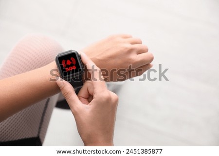 Woman using SOS function on smartwatch outdoors, closeup