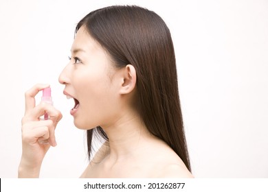 Woman Using Spray For Bad Breath